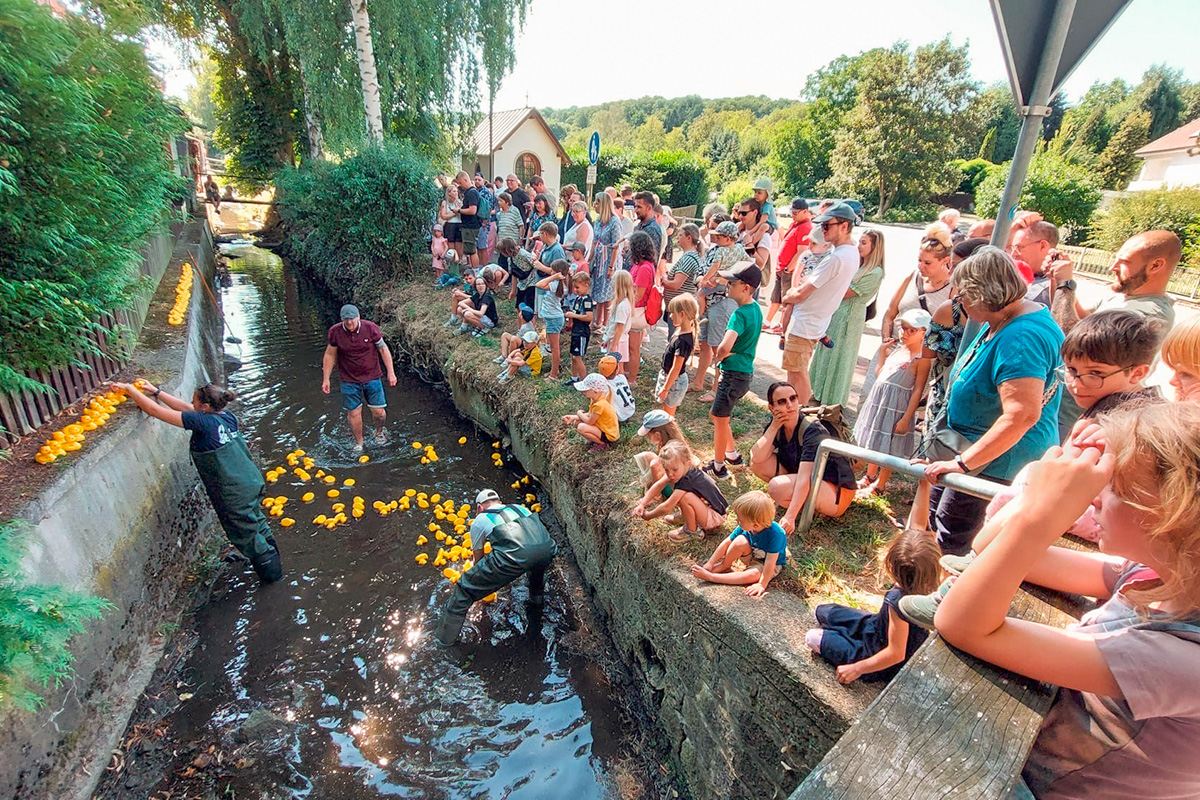 Die Besucherinnen und Besucher des Festes beobachten den Zieleinlauf der Rennenten am Heiligenhäuschen.