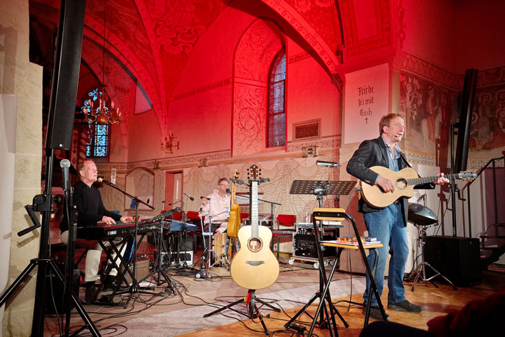 David Plüss, David Kandert und Clemens Bittlinger (von links) bewiesen auch in der stimmungsvoll beleuchteten Nettlinger Kirche, dass sie ein bestens eingespieltes Team sind.