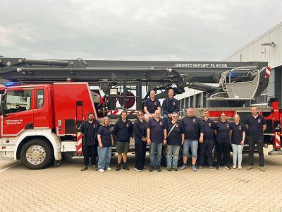 Kameradinnen und Kameraden der Freiwilligen Feuerwehr Bettrum vor der Teleskopmastbühne der Werkfeuerwehr Volkswagen AG Wolfsburg.