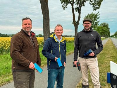 Marco Schmidt (Mitte), Vertreter der Öffentlichen in Wendeburg, übergibt 70 Wildwarnreflektoren für die K69 zwischen Meerdorf, Rüper und Wense, die Jagdpächter Markus Kobbe (links) und Maurice Debus